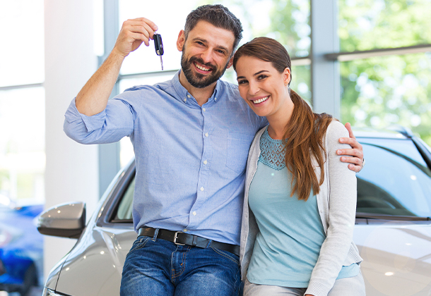 Couple holding car keys in dealership