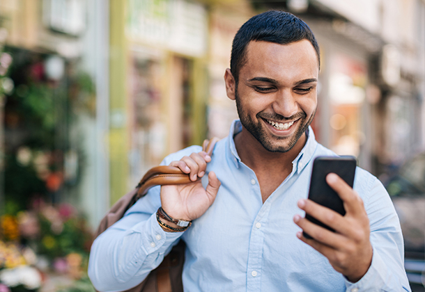 Man holding cell phone and smiling