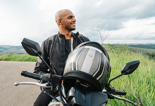 person on a motorcycle on a road with hills in background