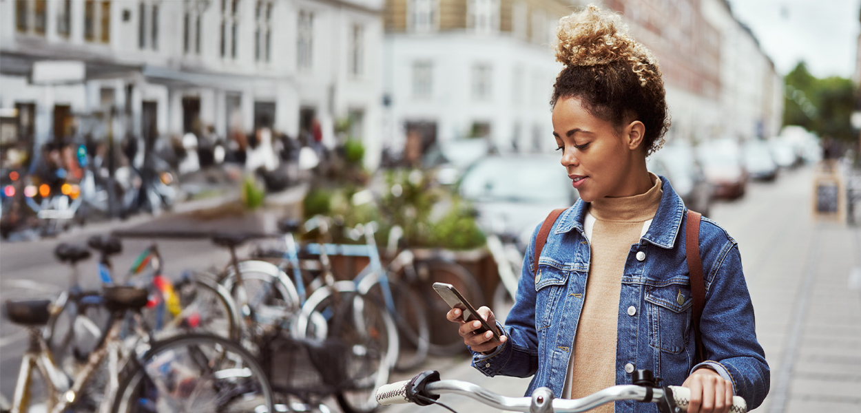 Person holding phone while on bike in outdoor setting