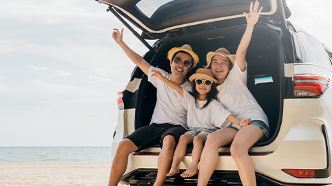 Happy Family in a car at the beach